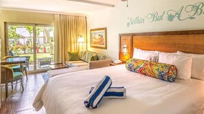 Ein Hotelzimmer mit einem großen Bett, einem Schreibtisch und Blick ins Freie.
