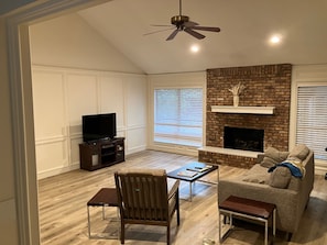 A living room with a fireplace, a television, and a ceiling fan. - Two bedroom Westlake house, very convenient to downtown and Zilker / ACL (Austin)