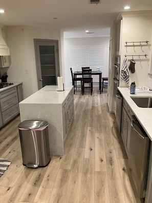 A modern kitchen with a central island, wooden flooring, and stainless steel appliances. - Two bedroom Westlake house, very convenient to downtown and Zilker / ACL (Austin)