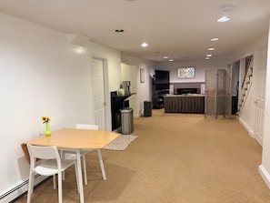 A modern kitchen with a built-in oven, a dining area with a table and chairs, and a living room with a sofa and a fireplace. - Beautiful 2-bedroom apartment in welcoming Newton neighborhood (Newton)