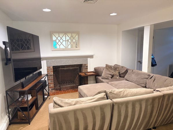 A living room with a fireplace, a sofa, a TV, and a wooden coffee table.