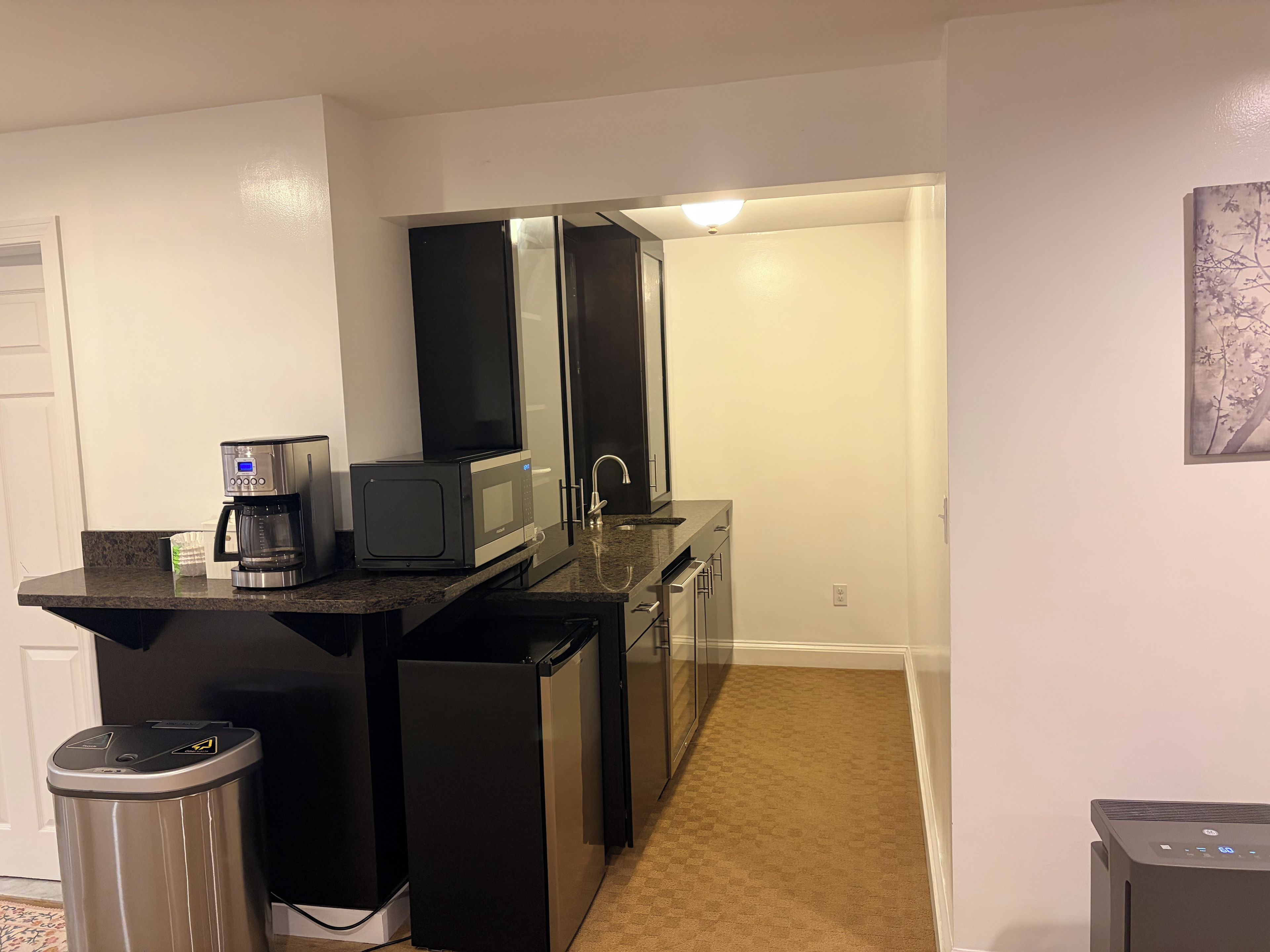 A compact kitchen with a coffee maker, microwave, and refrigerator.