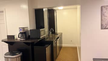 A compact kitchen with a coffee maker, microwave, and refrigerator.