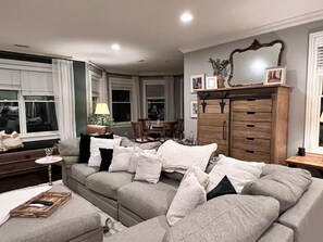 Ein Wohnzimmer mit einer Couch, einem Holzkasten und einem Essbereich.