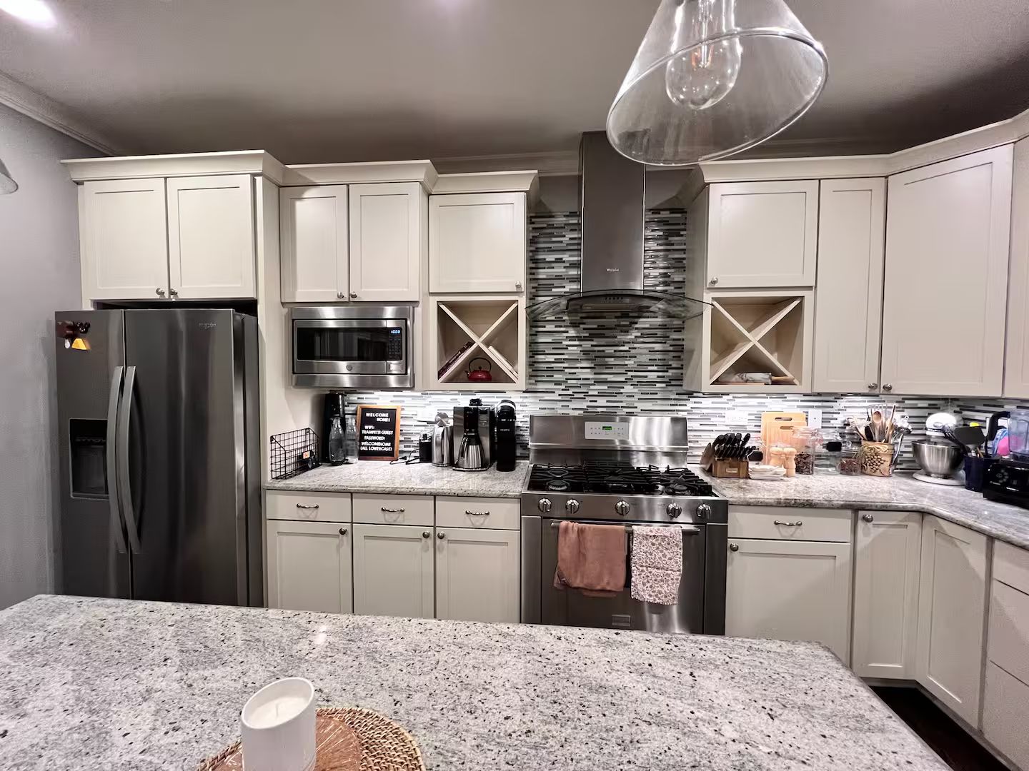 A modern kitchen with stainless steel appliances, a granite countertop, and a central island.
