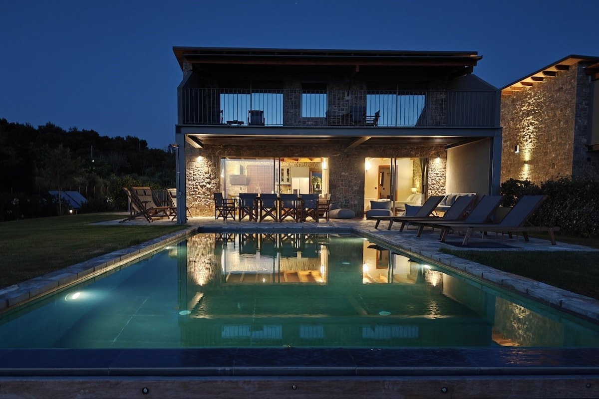 A two-story house with a swimming pool in the foreground.