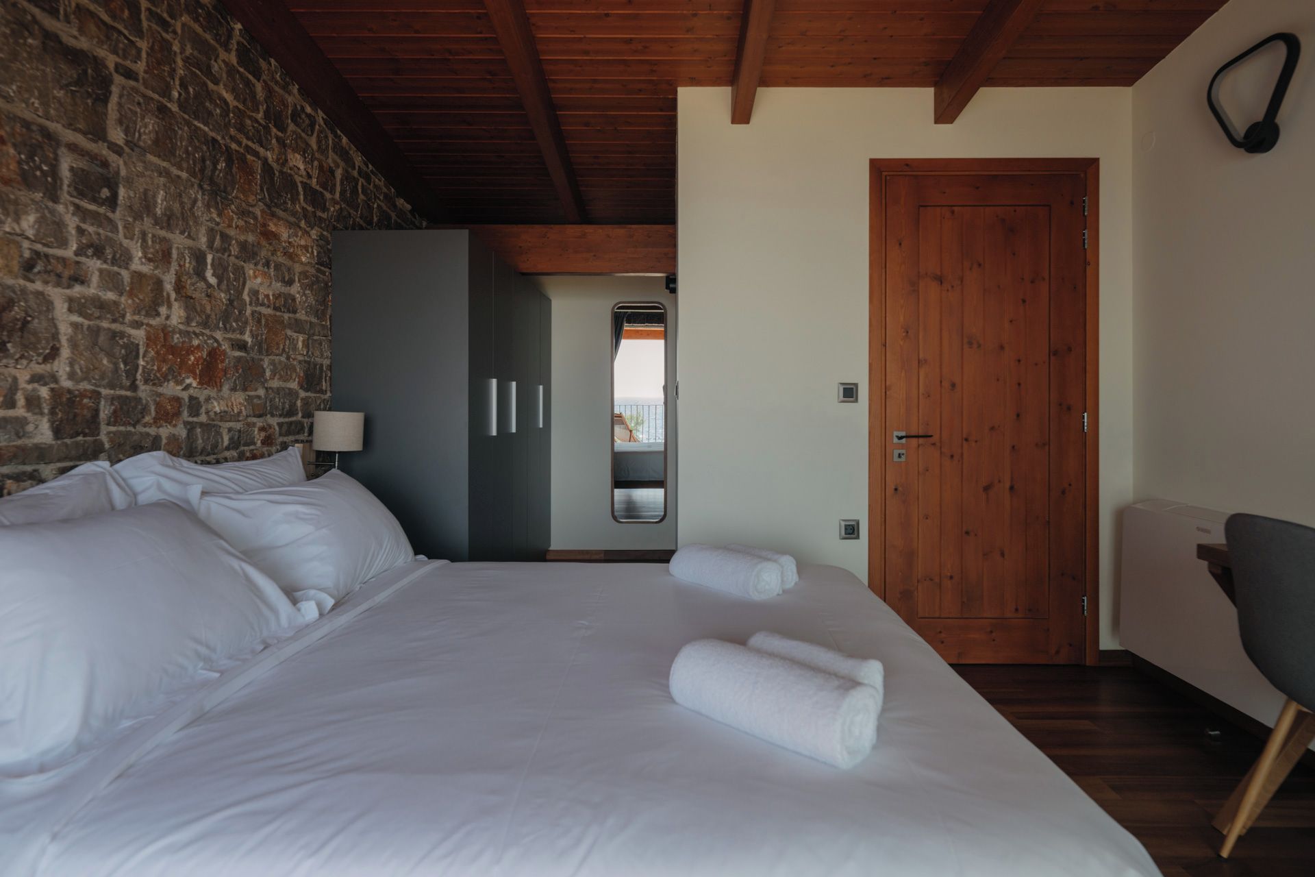 Una camera da letto con un letto grande, una porta in legno e una vista dalla finestra.