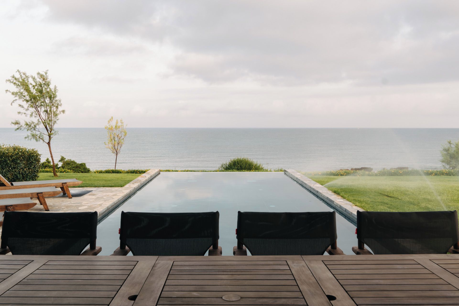 Un espacio con mesas y sillas al aire libre, con vista al mar.