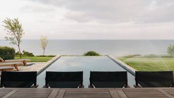 Un espacio con mesas y sillas al aire libre, con vista al mar.