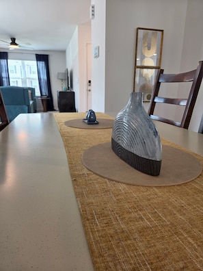 A dining table with a vase and a decorative item on placemats. - NEW corner lot FURNISHED 3 BR, 2.5 bath townhouse N Raleigh w/security/Internet. (Raleigh)
