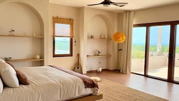 Quarto com cama, ventilador de teto, janela e vista para o exterior.