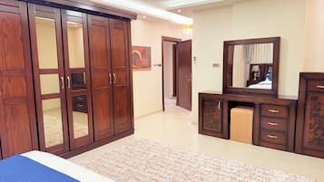A bedroom with a large wardrobe, a dresser, and a mirror.