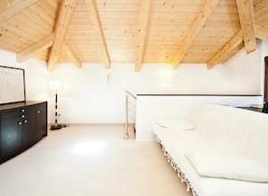 A room with a high wooden ceiling, a white sofa, a black cabinet, and a lamp. - Rialto - Bright Roof Studio (Venezia)