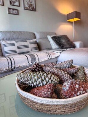 A living room with a sofa, a coffee table with a woven basket containing pinecones, and a floor lamp. - City View Apartment for 4 | Tressesenta Tower | Punta del Este (Punta del Este)