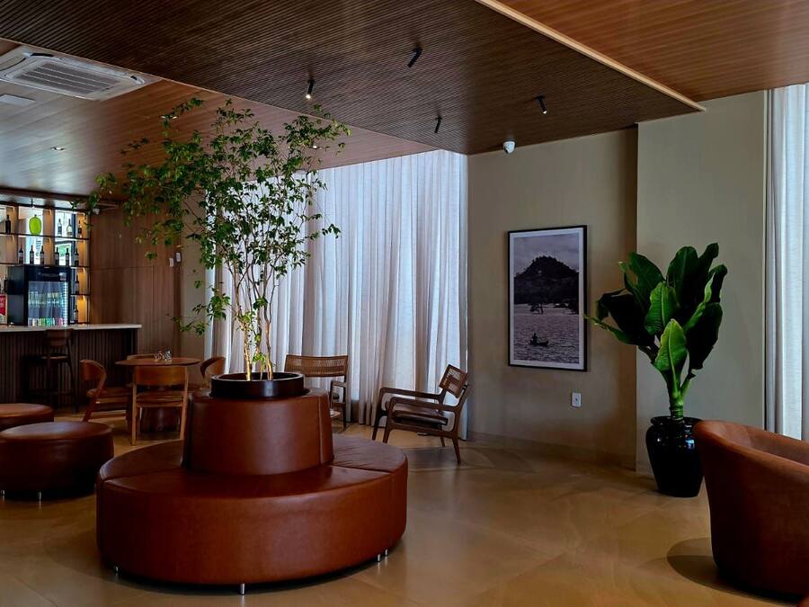 A lobby with a bar area, seating, and large windows.