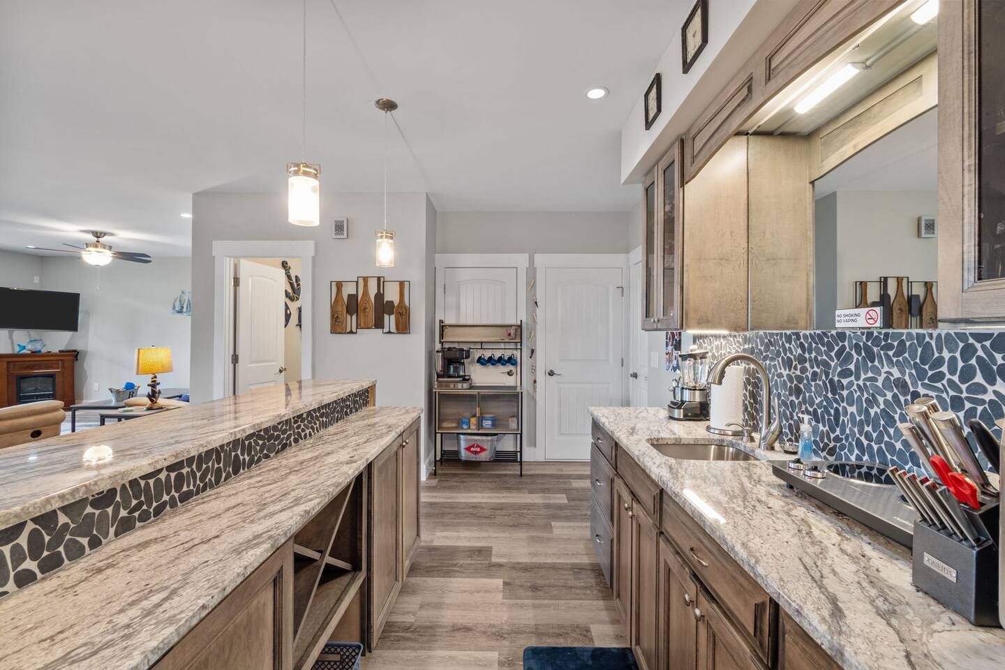 A modern kitchen with granite countertops, a built-in stove, and a large island.