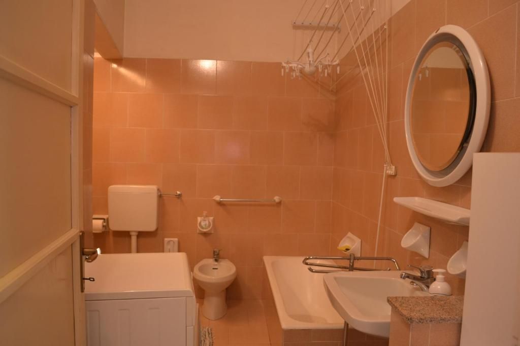 Une salle de bain équipée de toilettes, d’un bidet et d’une baignoire.