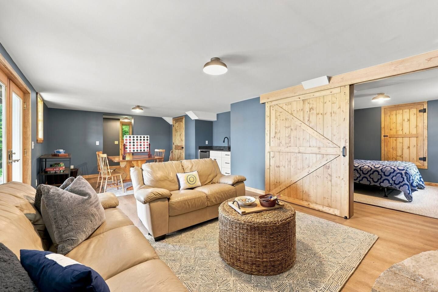 A modern living room with a sofa, a coffee table, and a dining area with a table and chairs.