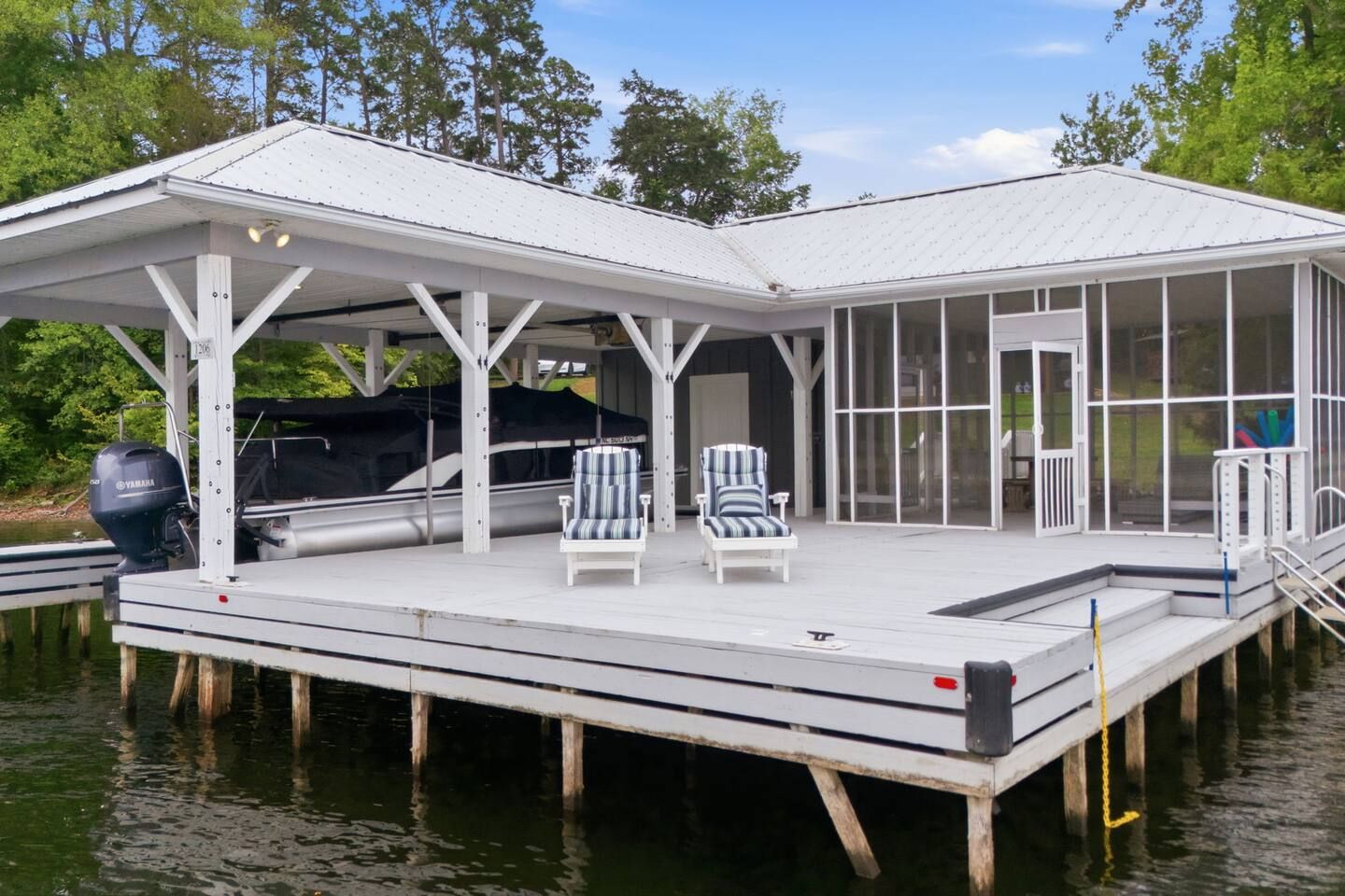 Guests can dock the boat right on the covered platform and lounge in the chairs beside the screened boathouse room.