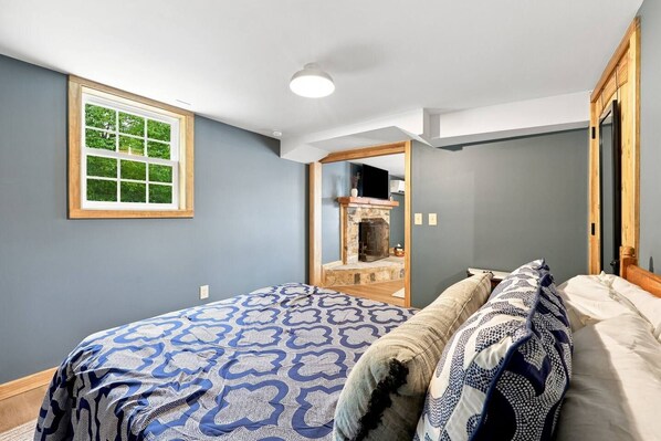 Un dormitorio con una cama, una ventana y una chimenea.