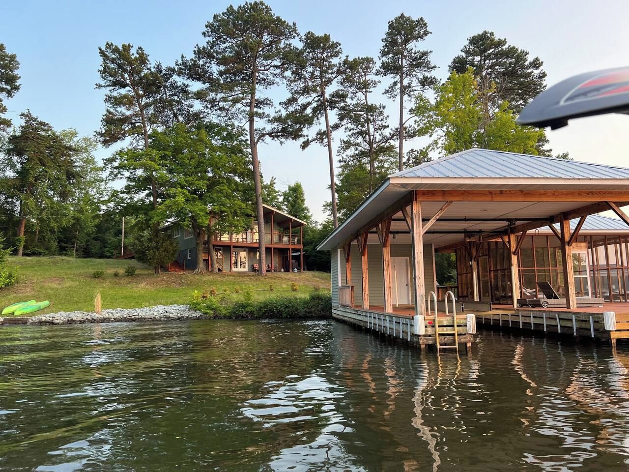A lakeside cabin with a dock, surrounded by trees.