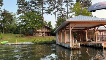 A lakeside cabin with a dock, surrounded by trees.