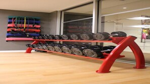 A gym with a rack of dumbbells and resistance bands.