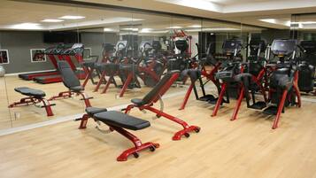 A gym with various exercise equipment, including treadmills, stationary bikes, and weight machines.