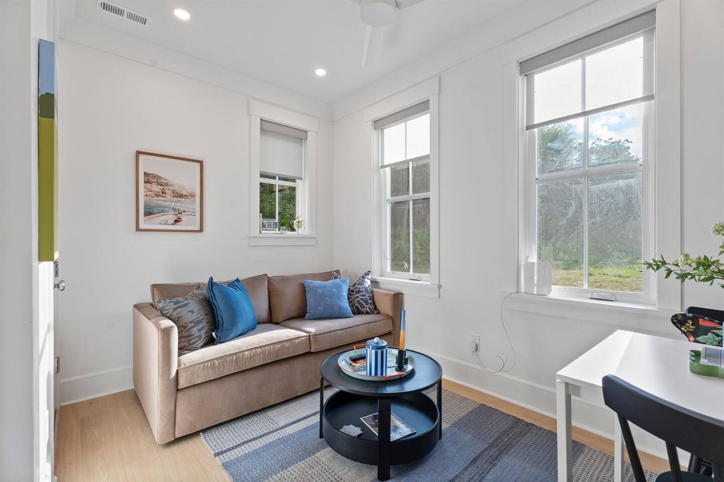 Un salon moderne avec un canapé beige, une table basse et une table à manger.