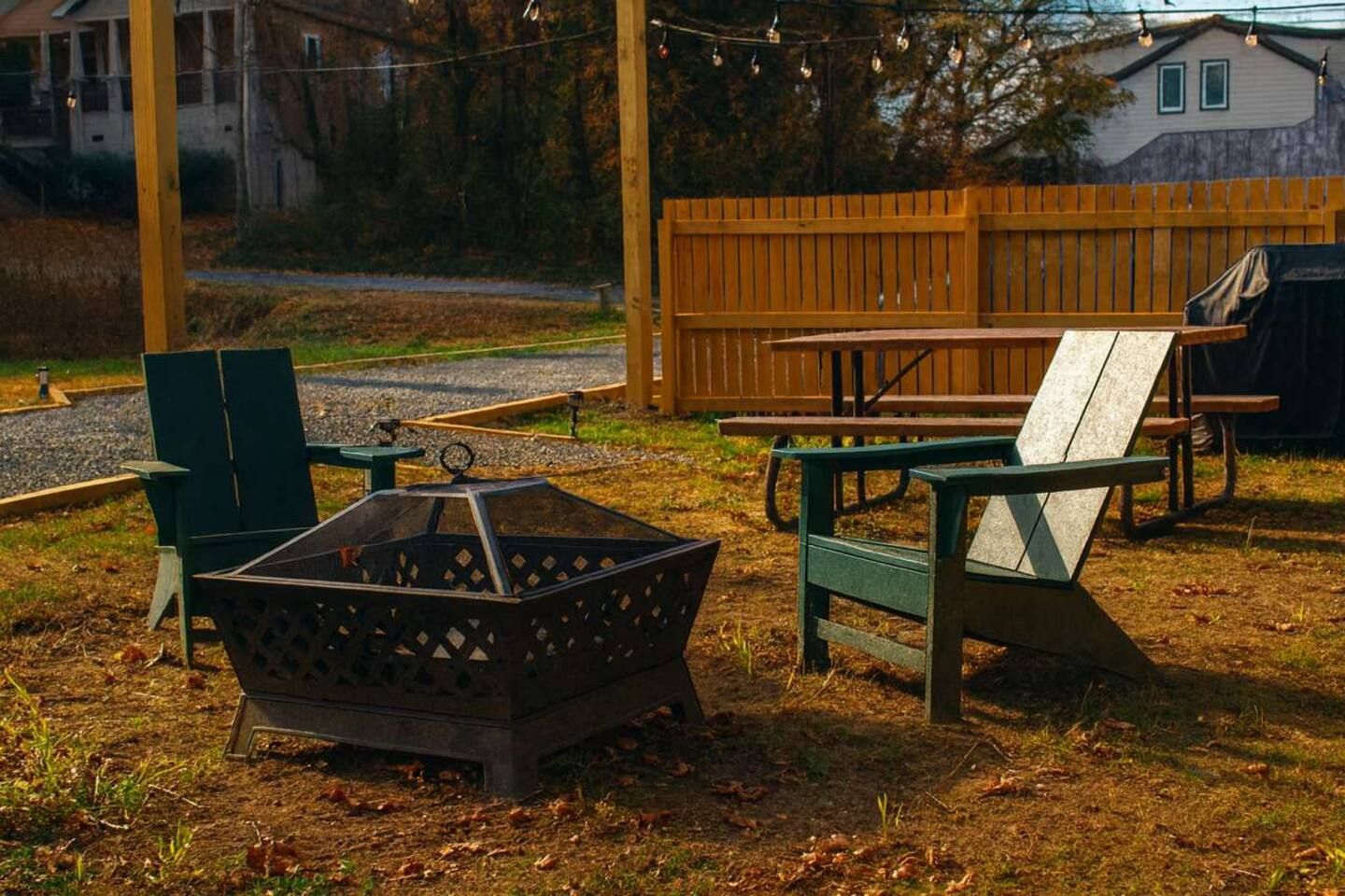 Un área de estar al aire libre con una chimenea, una mesa de picnic y sillas.