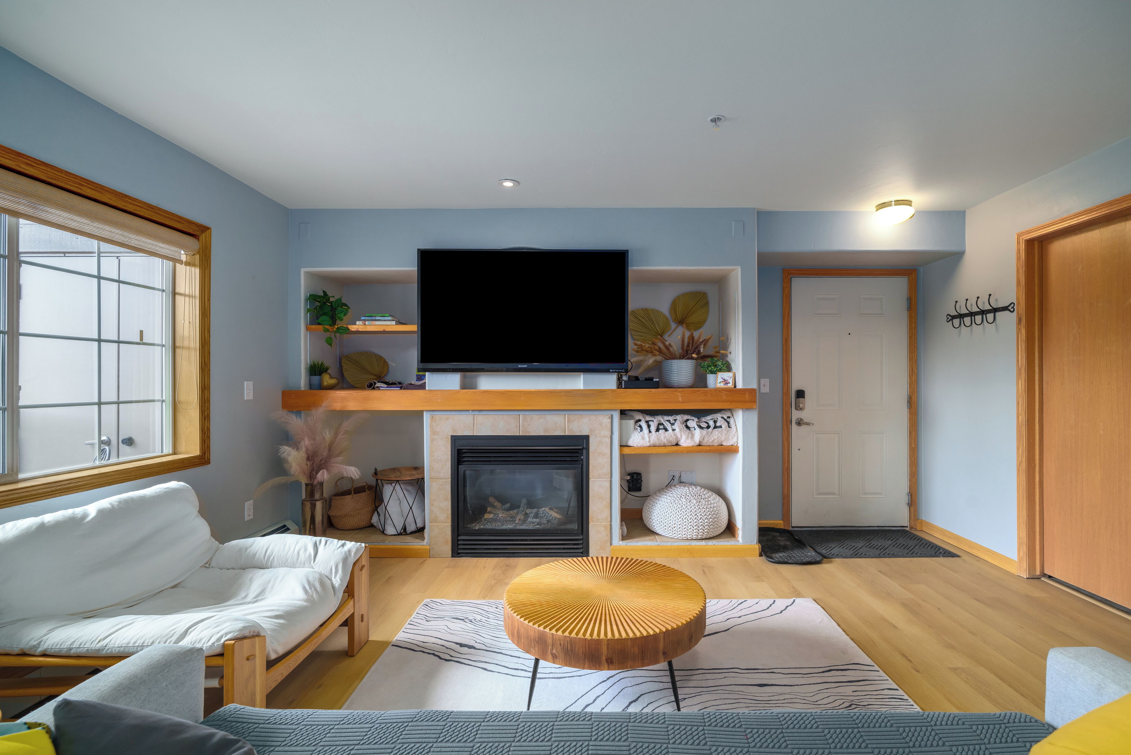 A living room with a flat-screen TV, a fireplace, a sofa, and a coffee table.