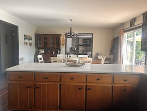 A kitchen with a large island, wooden cabinets, and a chandelier. - Spacious 4 Bedroom tranquil & secluded family retreat! (Ellenville)