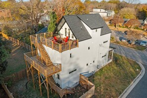 A two-story house with a balcony, a staircase, and a fenced yard. - Sky Deck - New Build - Downtown - Fenced - FirePit (Raleigh)