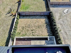 An aerial view of a backyard with a wooden fence, a concrete planter, and a grassy area. - 4 Ensuite Flats, Downtown, Architecture, Skyline (Raleigh)