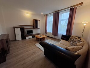 Ein modernes Wohnzimmer mit einer Couch, einem Couchtisch, einem Fernseher und einem Einbauschrank.