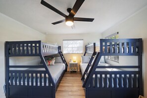 A bunk bed room with a ceiling fan, a window with blinds, and a small bedside table with a lamp. - Private Resort w/ Heated Pool, Pickleball Court, Firepit... Near IMG and Beach! (Bradenton)