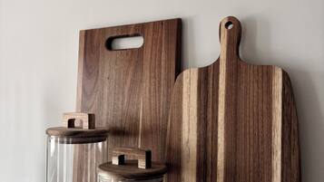 Una encimera de cocina con dos tablas de cortar de madera y dos tarros de vidrio con tapa.