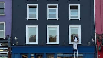 A building with a dark facade, multiple windows, and a blue storefront.