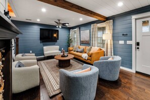 A living room with a sofa, armchairs, a coffee table, and a TV. - Prather Ridge Estate | 3BR | Bourbon + Pickleball + Sauna (Chaplin)