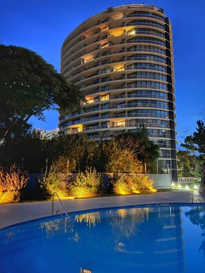 A multi-story hotel with a pool in the foreground. - High-Floor 1-Bedroom Apartment with City Views | Tressesenta Tower (Punta del Este)
