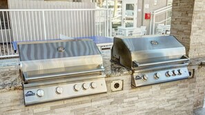Deux barbecues à gaz Premier en acier inoxydable, fixés sur un mur en pierre.