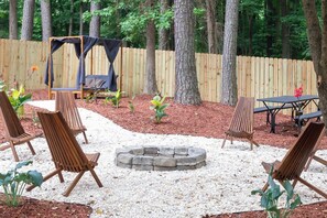 A backyard with a fire pit, outdoor furniture, and a wooden fence. - Outdoorsy, Sauna, Ice Bath, Pets OK, 10 min Dtwn (Raleigh)