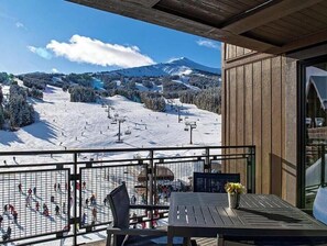 Un balcon avec vue sur une piste de ski et une montagne.