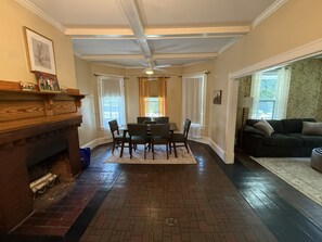 A dining area with a fireplace, a table with chairs, and a sofa in the adjacent living room. - Cozy 1-bedroom apartment in adorable Saint Albans City (Saint Albans City)