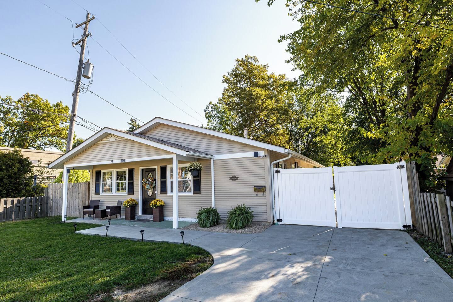 A single-story house with a covered porch, a fenced yard, and a driveway.