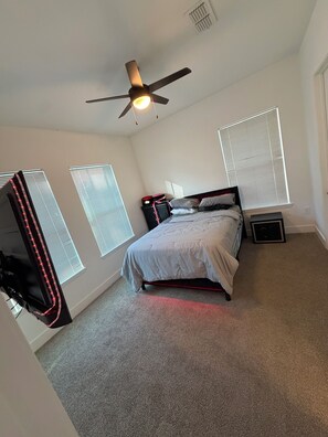 A bedroom with a bed, ceiling fan, and window blinds. - The Midnight Escape/Fast&Furious Suite (Atlanta)