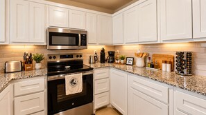 A modern kitchen with white cabinets, stainless steel appliances, and granite countertops. - NEW..Walk to UMHB & Downtown & 3BR & Pets Welcome (Belton)