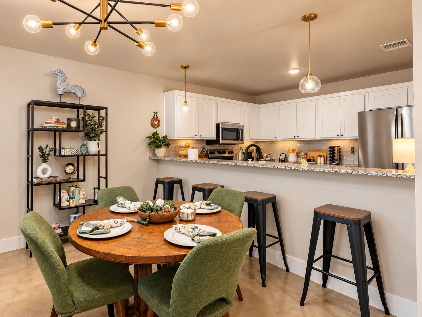 A modern kitchen with white cabinets, a stainless steel refrigerator, and a wooden dining table with green chairs.