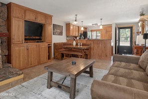Un salon spacieux avec une table basse en bois, un canapé et une cheminée en pierre.