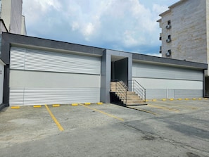 Entrada a un estacionamiento con una escalera que sube a un nivel superior.